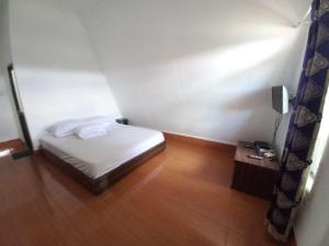una piccola camera con letto bianco e pavimento in legno di Collection O 92634 Villa Ds a Sumedang