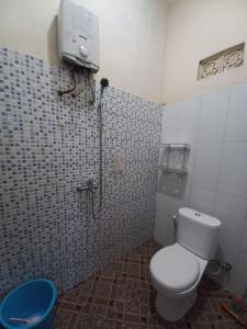 a small bathroom with a toilet and a shower at Collection O 92634 Villa Ds in Sumedang
