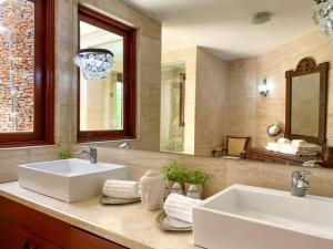a bathroom with two sinks and a large mirror at Mangos 13 Beautiful 5 bedroom villa with maid golf cart in La Romana