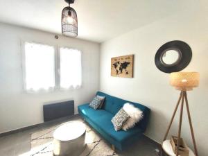 a living room with a blue couch and a lamp at Cosy F2 à proximité de PARIS in Savigny-sur-Orge