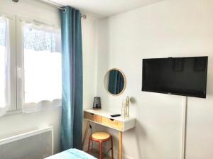 a bedroom with a desk and a tv on a wall at Cosy F2 à proximité de PARIS in Savigny-sur-Orge