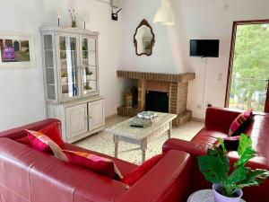 een woonkamer met rode banken en een open haard bij Villa Secret Paradise, Costa Brava in Lloret de Mar