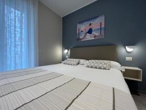 a bedroom with a large bed and a large window at Adelasia al Corso in Alassio