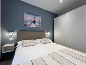 a bedroom with a white bed and a blue wall at Adelasia al Corso in Alassio