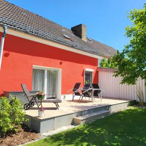 a house with a deck with chairs and a table at Haus Nutheblick - Komfort Appartement in Trebbin