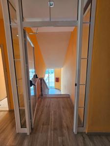 a hallway with glass doors leading into a room at SunBorn Hotel in Golem