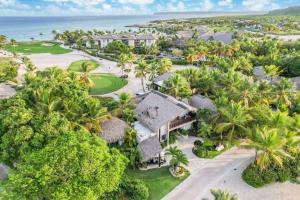 an aerial view of a resort with palm trees and the ocean at Caleton 16 Ocean view 5 bedroom villa with Chef Butler Maid Golf Cart in Punta Cana