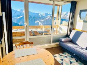 sala de estar con sofá y ventana grande en Apartment amazing view in Alpe Huez, 4 person, en LʼHuez