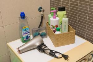 eine Badezimmertheke mit Hygieneprodukten und einem Haartrockner in der Unterkunft La AMISTAD Apartamento en Chalet con piscina compartida in Calpe