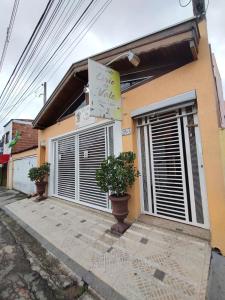 uma casa com dois vasos de plantas em frente em Pousada Lirio do Vale em Cachoeira Paulista