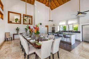 a dining room with a table and chairs and a kitchen at VILLA HERMOSA CHEF MAiD POOL JACUZZI GOLF CART in La Romana
