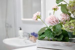 een vaas met roze bloemen op een aanrecht in een badkamer bij Arrecife 4 U in Arrecife