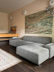 a living room with two couches and a painting on the wall at Meza House Apartment in Jūrmala