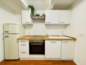 a kitchen with white cabinets and a refrigerator at Garibaldi Accommodation in Viterbo