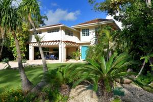 una casa blanca con palmeras delante en Villa Careta Tortuga B55, en Punta Cana