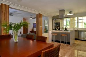 a dining room and living room with a table and a kitchen at Villa Careta Tortuga B55 in Punta Cana