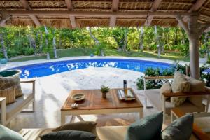 a patio with a table and a large pool at Villa Careta Tortuga B55 in Punta Cana