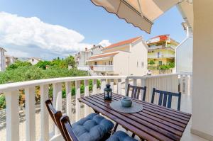 a wooden table and chairs on a balcony with a view at Guesthouse Maestral in Trogir