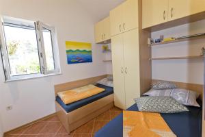 a small room with two beds and a window at Apartment By the sea in Donje Selo na Šolti