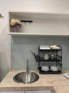 um balcão de cozinha com um lavatório e uma prateleira em Beautiful Studio x King bed em Ho Chi Minh