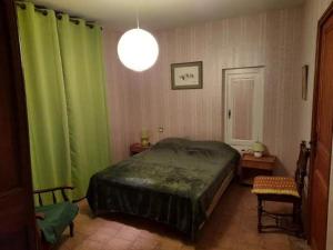 - une chambre avec des rideaux verts et un grand lit dans l'établissement mas cevenol, à Rosières
