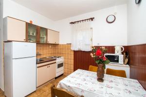 une cuisine avec une table et un vase de fleurs. dans l'établissement Apartments Zivana, à Žaborić