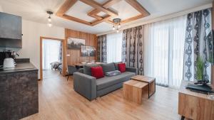 a living room with a couch and a table at Apartamenty Sun & Snow SKI Apartments in Białka Tatrzańska