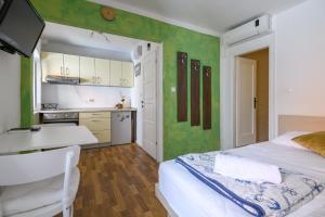 a bedroom with a bed and a desk and a kitchen at Studio Esperanza Dubrovnik in Dubrovnik