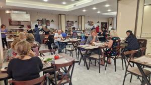 a group of people sitting at tables in a restaurant at Sun City Hotel & Spa Naftalan in Naftalan