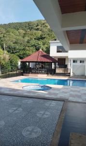 a swimming pool with a gazebo next to a building at Naru in Utica