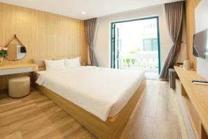 sypialnia z dużym białym łóżkiem i oknem w obiekcie Golden Dragon Hotel w Duong Dong