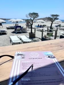 Un periódico sobre una mesa junto a una playa. en LE GEISHA, en La Grande-Motte