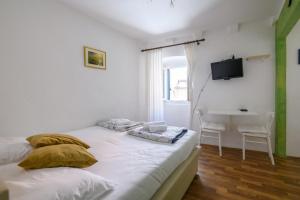 a bedroom with a bed and a desk and a television at Studio Esperanza Dubrovnik in Dubrovnik
