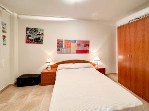 En eller flere senge i et værelse på CENTRIC APARTMENT with POOL in TOSSA 2