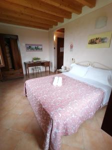 ein Schlafzimmer mit einem großen Bett und einem Tisch in der Unterkunft Agriturismo Nuvolino in Monzambano