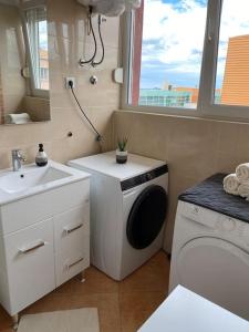 uma casa de banho com uma máquina de lavar roupa e um lavatório em Apartman Dora, Sibenik, Sibensko-kninska em Sibenik