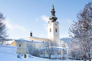 a large building with a clock tower in the snow at Seminarzentrum Stift Schlägl in SchlÃ¤gl