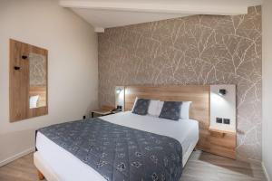 - une chambre avec un lit et un mur dans l'établissement Charme Hôtel et Spa, Montbéliard Sud, à Montbéliard