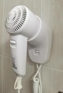 a white hair dryer is attached to a wall at HOSTAL RIGAU in Sant Feliu de Guíxols