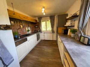 a kitchen with white cabinets and a sink at Ferienhaus mit Teich auf 16.000m² in der Natur in Hermannsburg