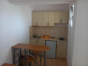 a small kitchen with a table and a refrigerator at Apartments Percobic in Sutomore