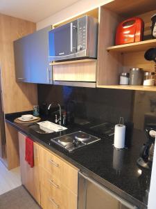 a kitchen with a stove and a microwave at Suite con piscina in Bogotá +24 photos