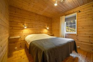 1 dormitorio con 1 cama en una habitación de madera en Gezellige woning met hottub en sauna en Vradal