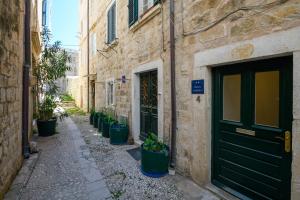 an alley with potted plants in front of a building at Studio Esperanza Dubrovnik in Dubrovnik