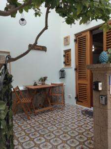 un patio con una mesa y una silla junto a una puerta en Al Limone, en Lipari