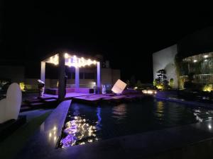 a person standing next to a swimming pool at night at Genting Highlands Peak 8paxCozyHome at Ion Delemen in Genting Highlands
