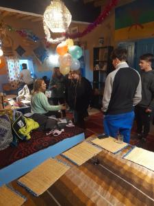 a group of people standing in a room with balloons at back to original home in Merzouga