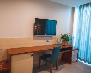 Zimmer mit einem Schreibtisch, einem TV und einem Stuhl in der Unterkunft Hotel Deloix 4* Sup in Benidorm