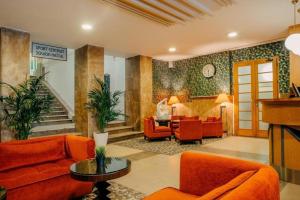 ein Wohnzimmer mit orangefarbenen Möbeln und einer Treppe in der Unterkunft Metropolitan Old Town Hotel - Czech Leading Hotels in Prag
