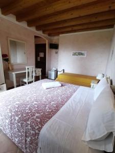 una camera con un grande letto e una scrivania di Agriturismo Nuvolino a Monzambano